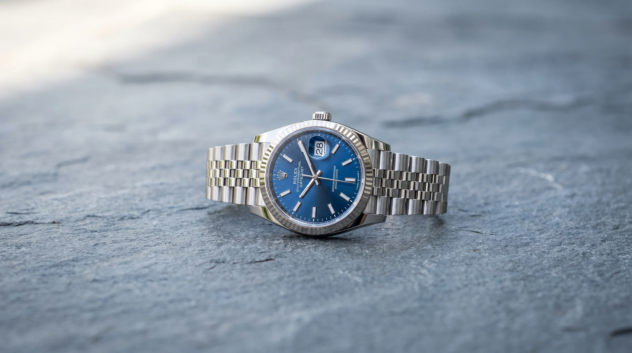 Steel Rolex Datejust 36 with blue dial and Jubilee bracelet on slate, a classic everyday luxury watch
