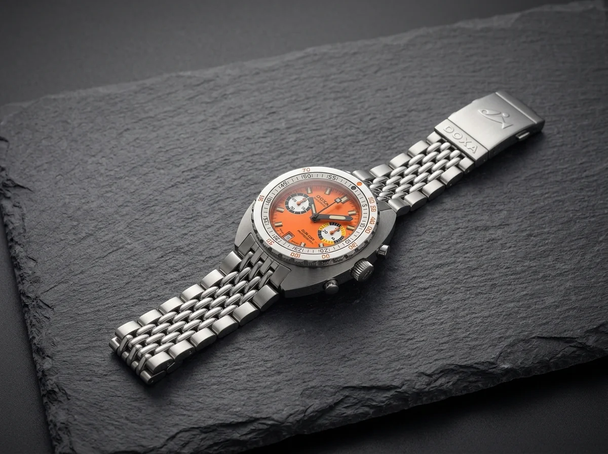 Orange-dial Doxa SUB 200 T.GRAPH II on a grey stone slab.