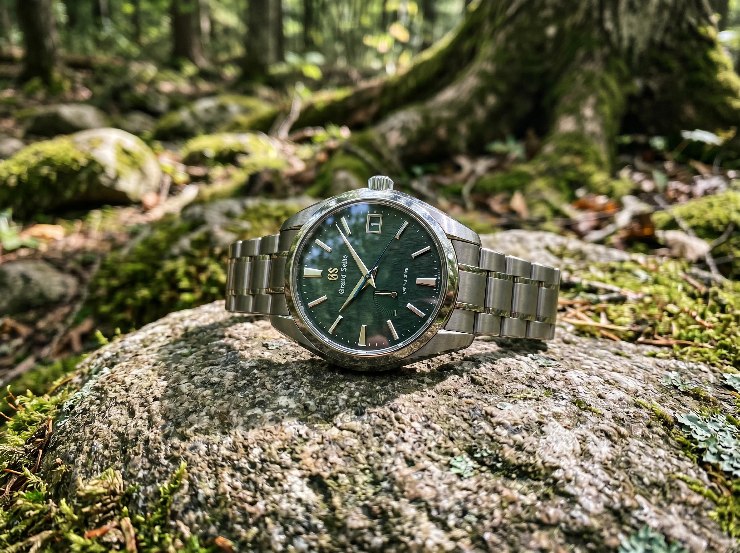 Grand Seiko Spring Drive with a deep green nature-textured dial resting on a mossy river stone