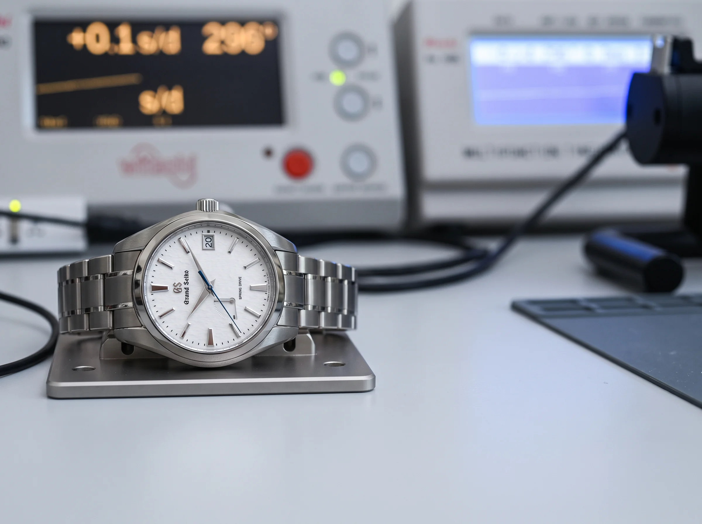 A Grand Seiko Spring Drive Snowflake resting on a precision electronic timing machine in a testing lab