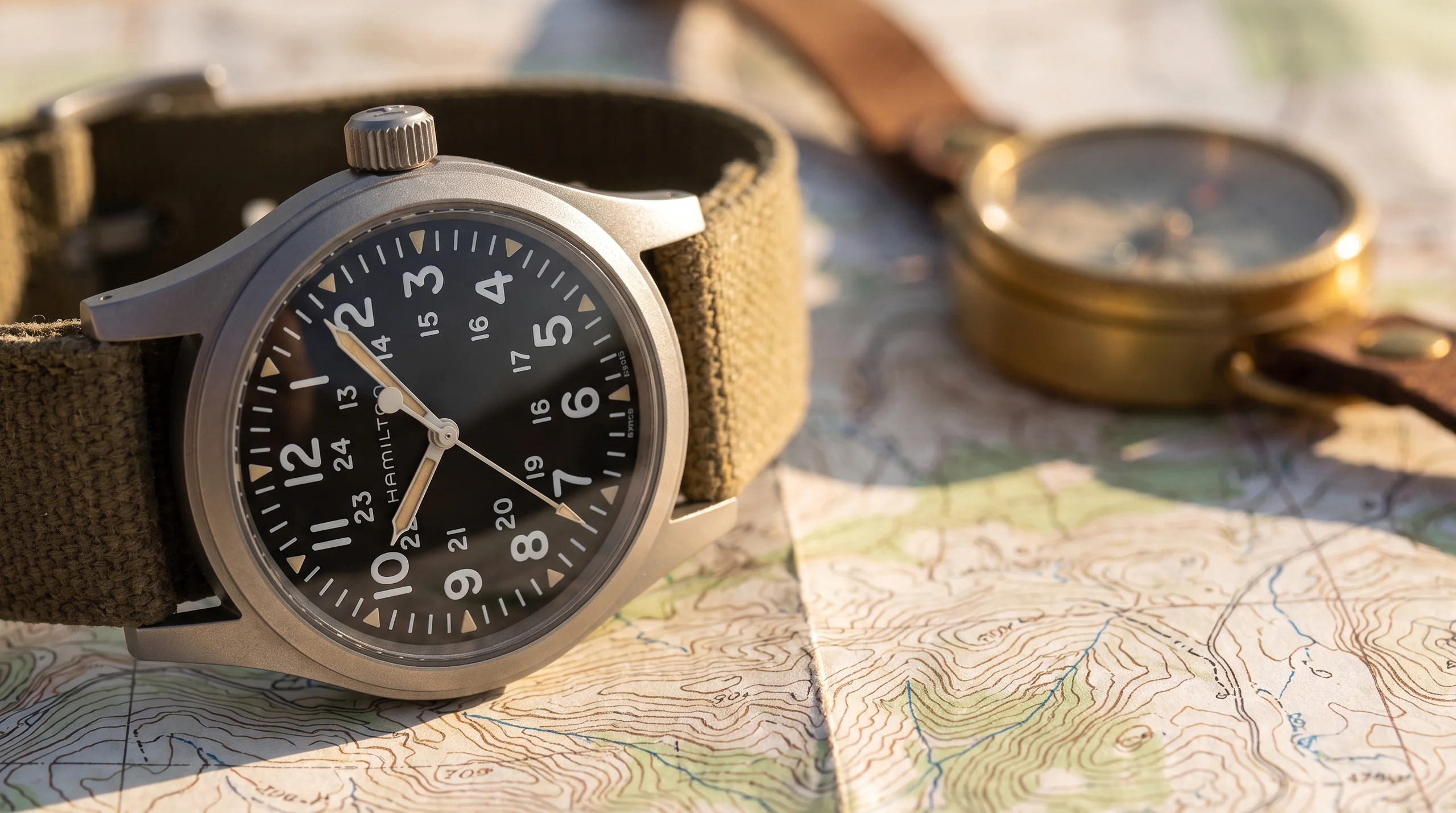 Macro of the Hamilton Khaki Field Mechanical dial and hand-wind crown on a topographic map