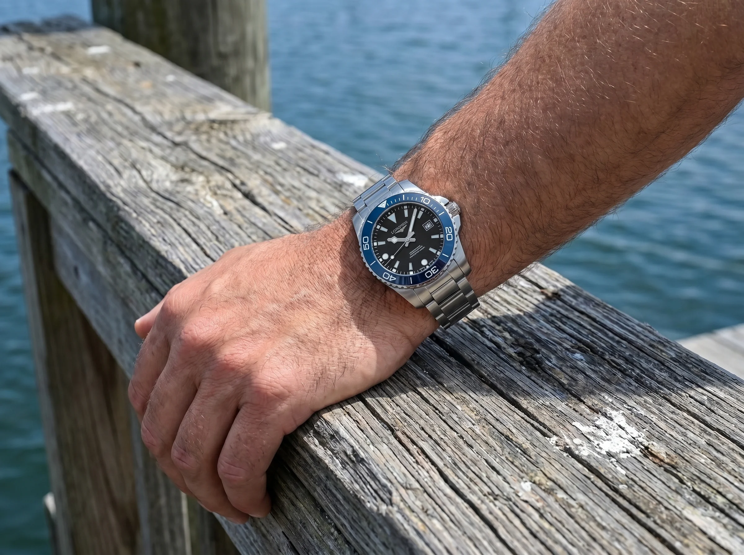The HydroConquest worn on a wrist resting on a wooden dock railing
