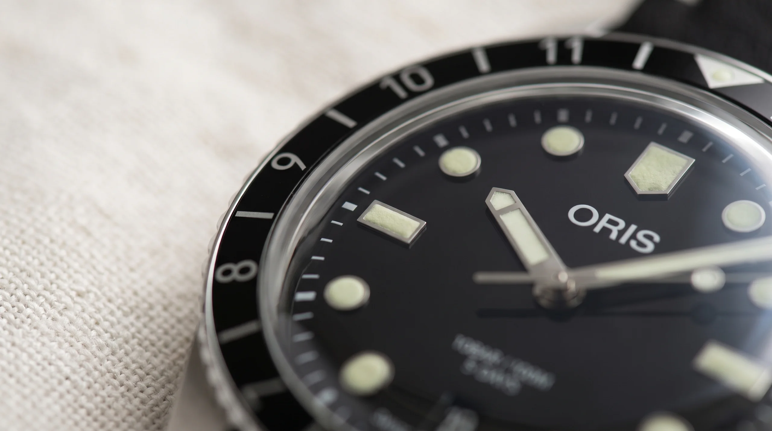 Daylight macro of cream-green Super-LumiNova packed into a dive watch's hands and hour markers