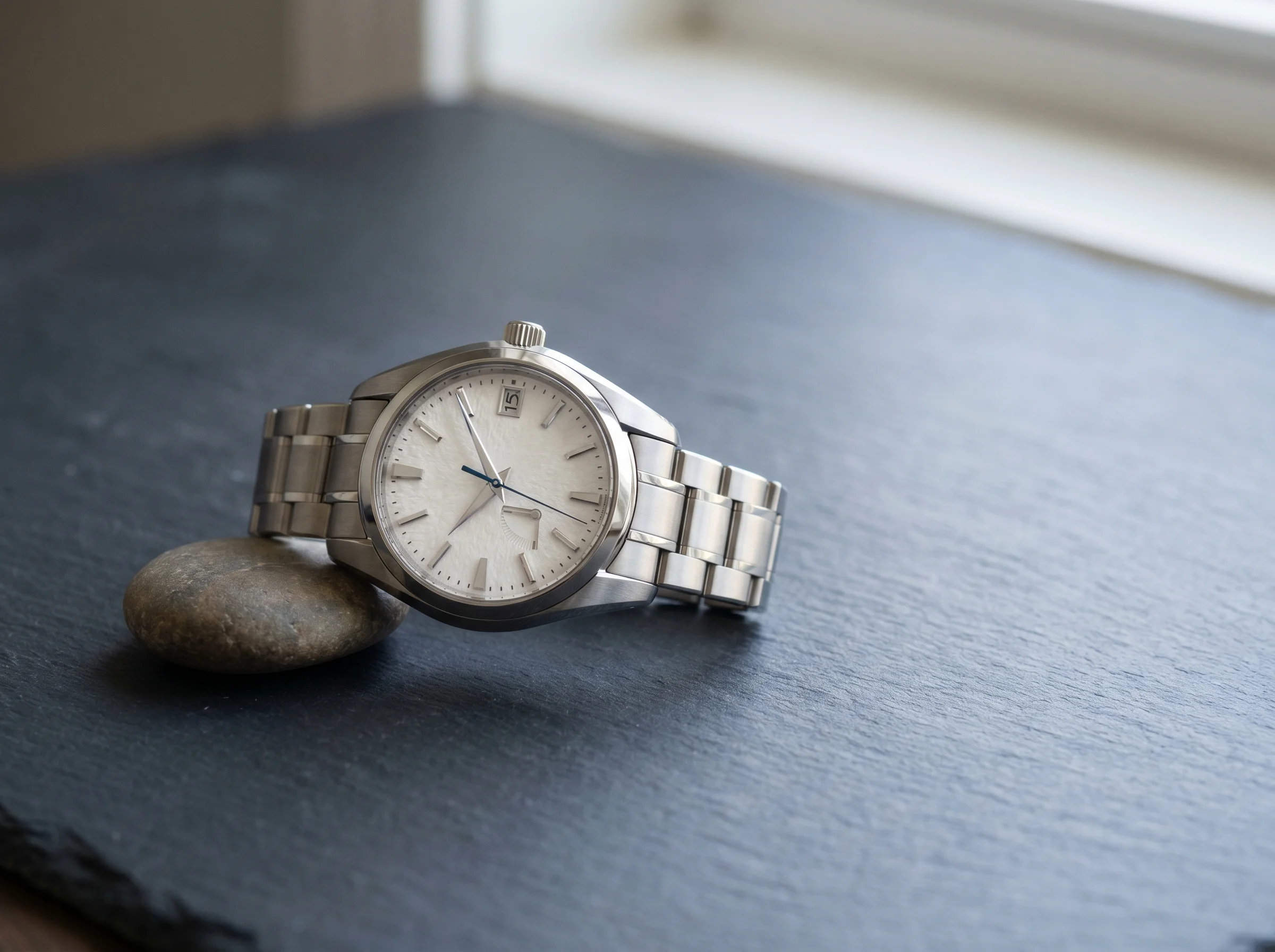 A Spring Drive-style watch with a textured snowflake dial, power-reserve indicator, and blued gliding seconds hand on slate