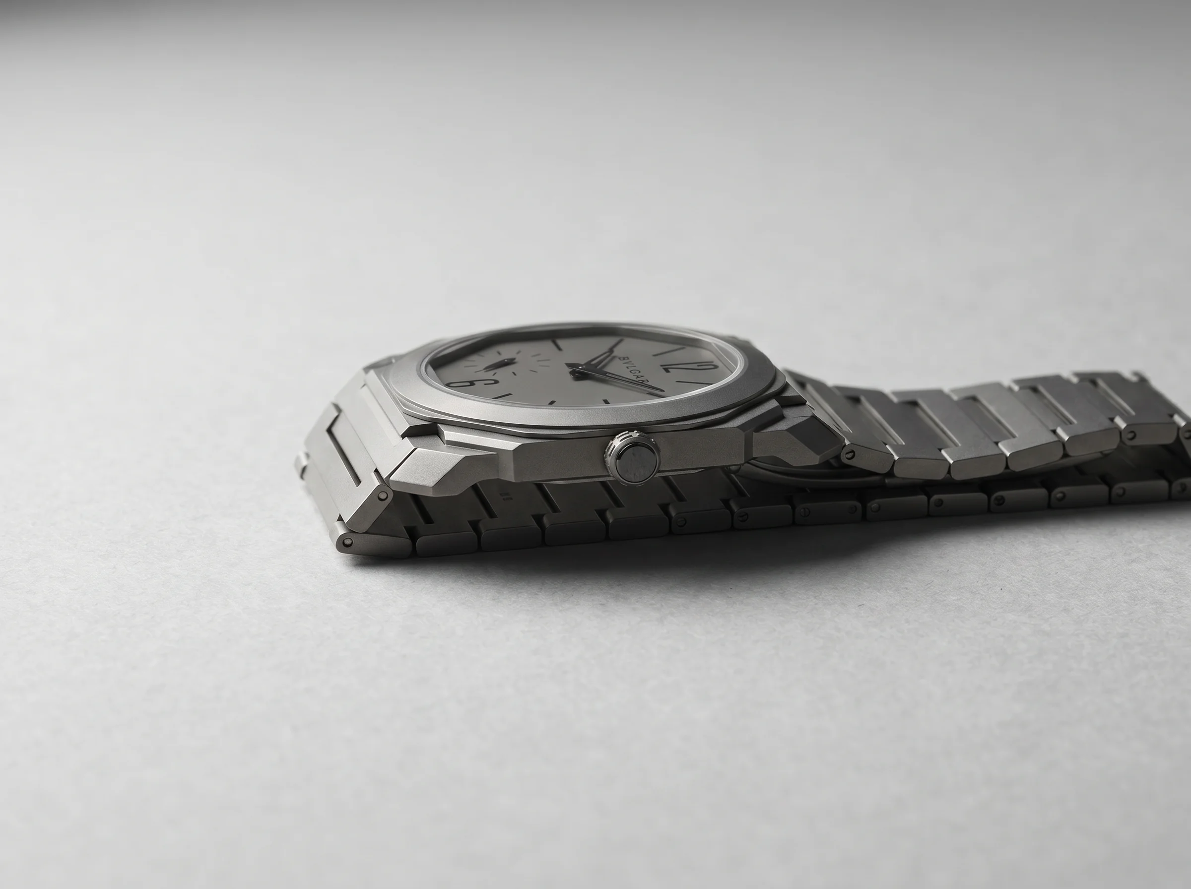 Side profile of an ultra-thin sandblasted titanium octagonal watch emphasizing its extremely slim case