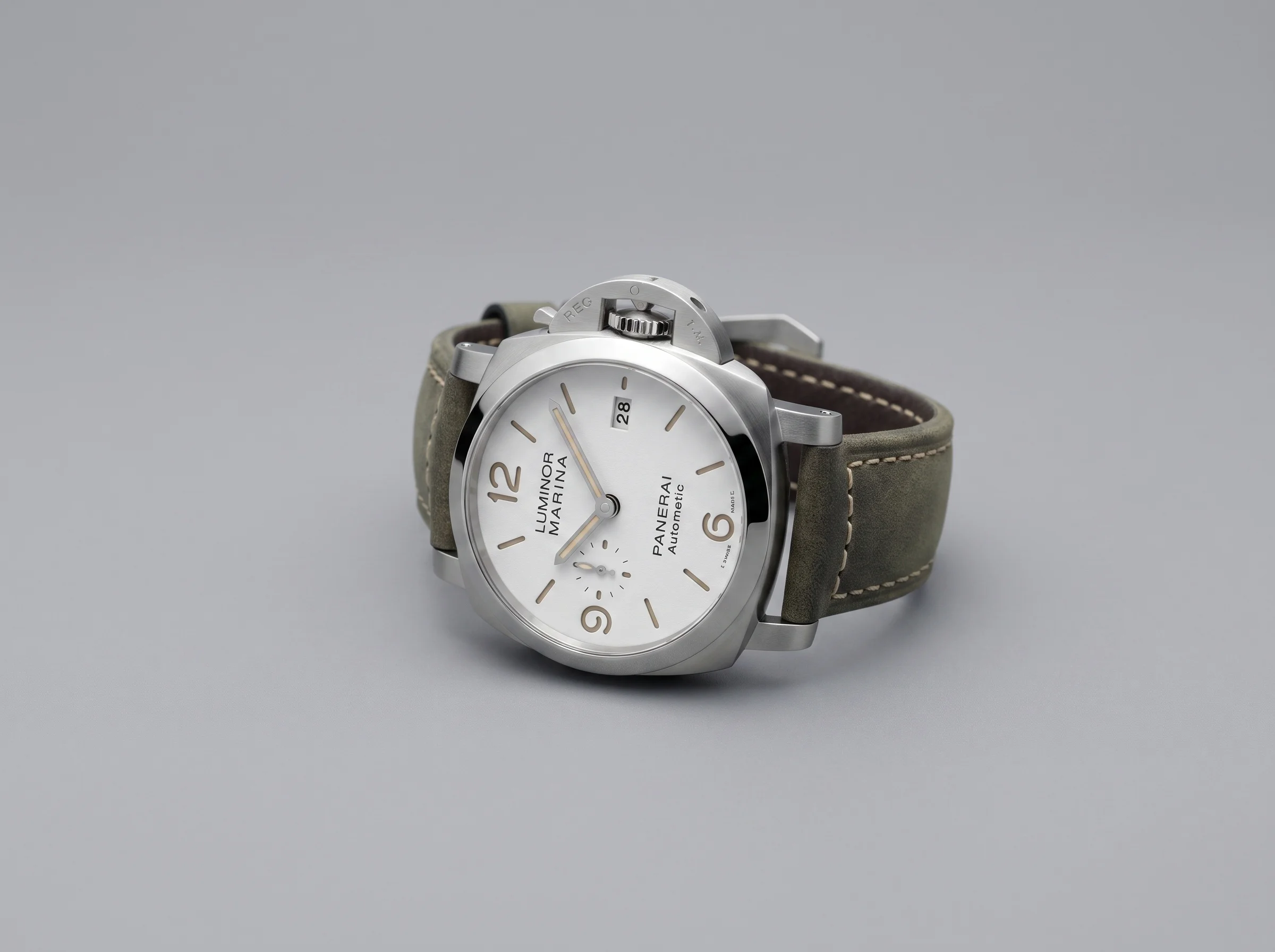 Studio shot of a Luminor-style cushion-case dive watch with a lever crown-guard bridge on a grey background
