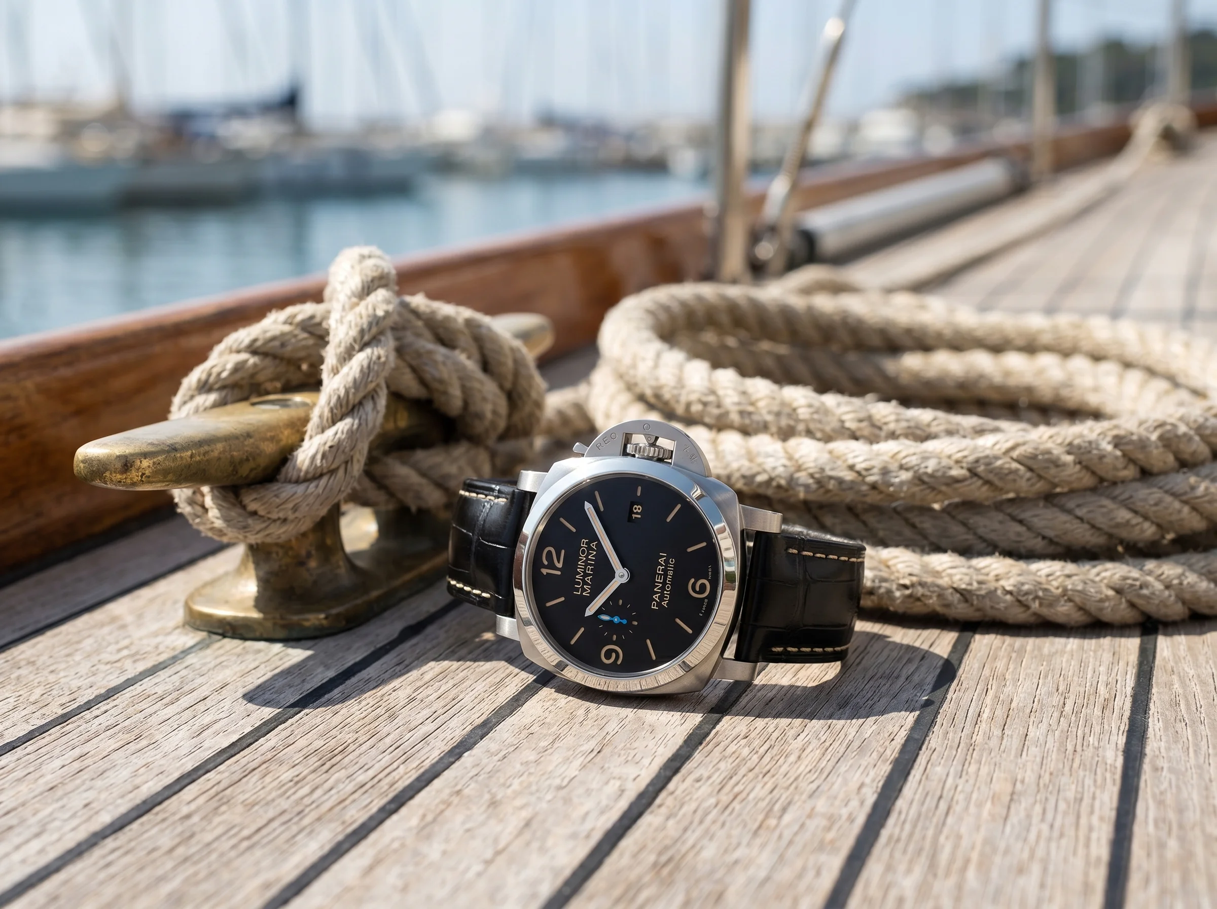 Panerai Luminor Marina PAM01312 resting on weathered teak boat decking beside nautical rope and a brass cleat