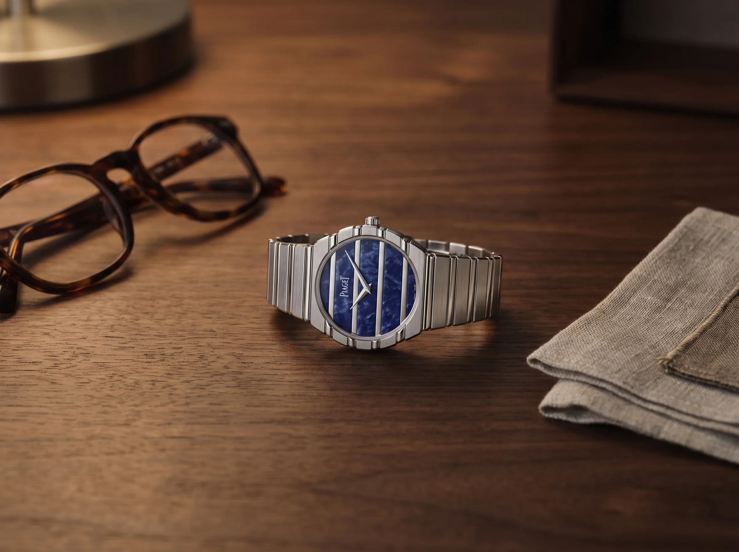 Piaget Polo 79 white gold with sodalite dial on a walnut desk beside tortoiseshell glasses