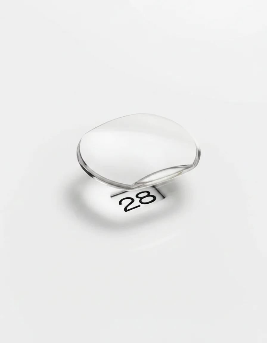 Macro shot of a watch date window and cyclops magnifier lens showing the date number 28