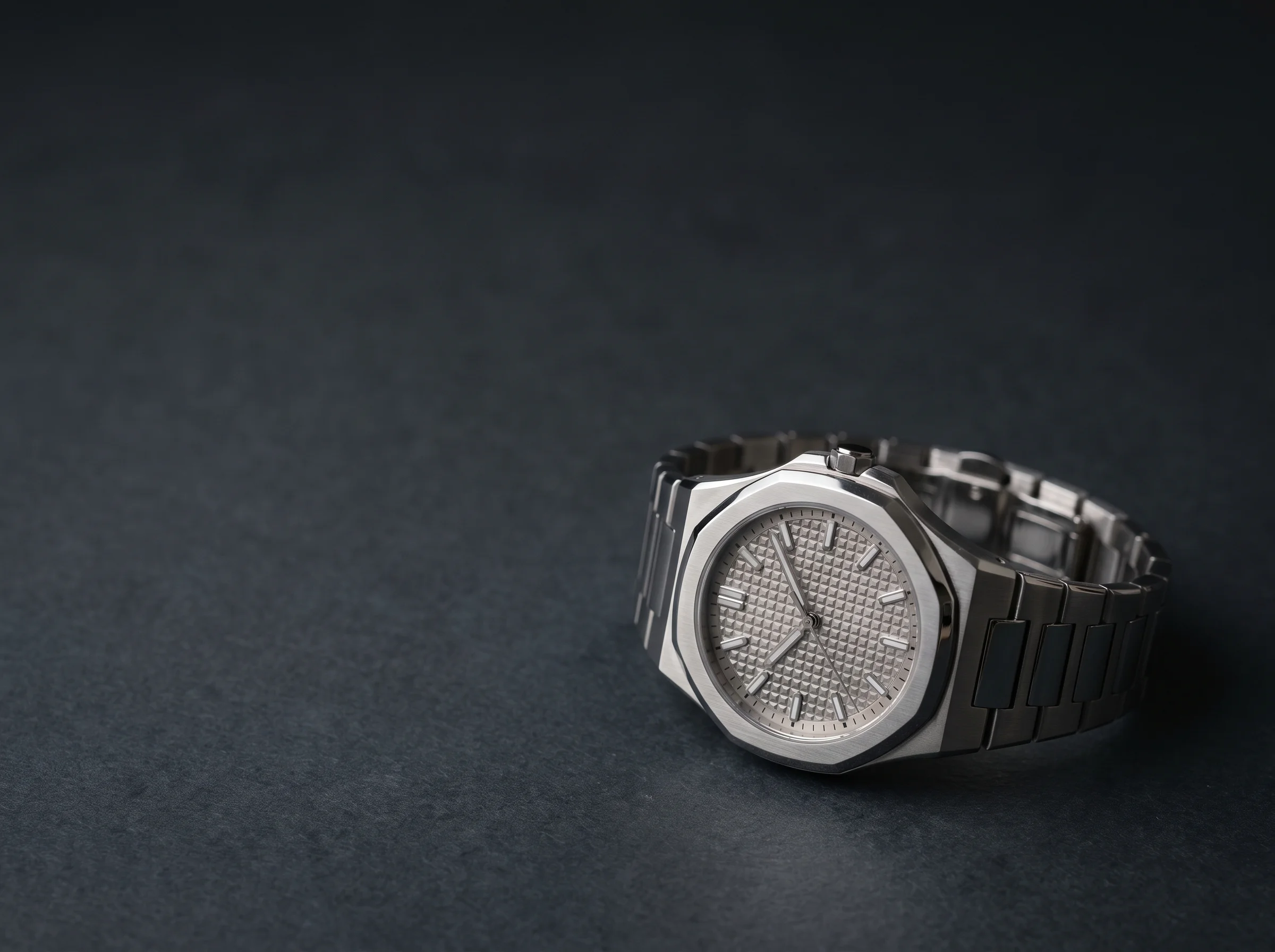 A more detailed integrated-bracelet sports watch with a twelve-sided polished bezel and a textured dial