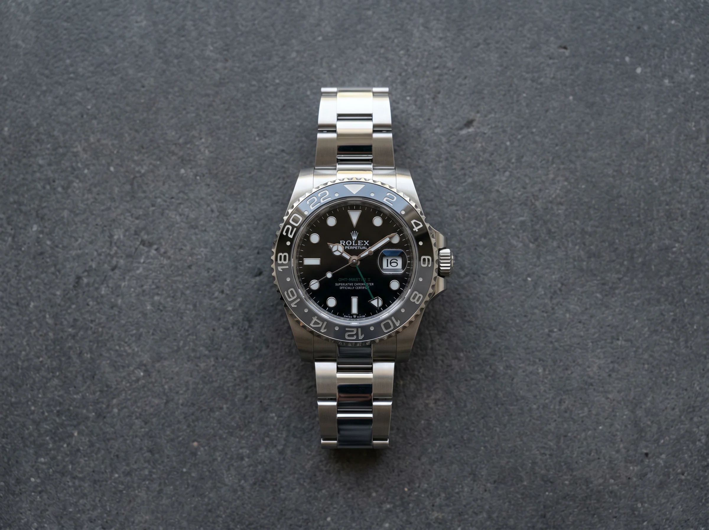 Top-down view of the Rolex GMT-Master II Bruce Wayne 126710GRNR with grey and black Cerachrom bezel and green GMT hand