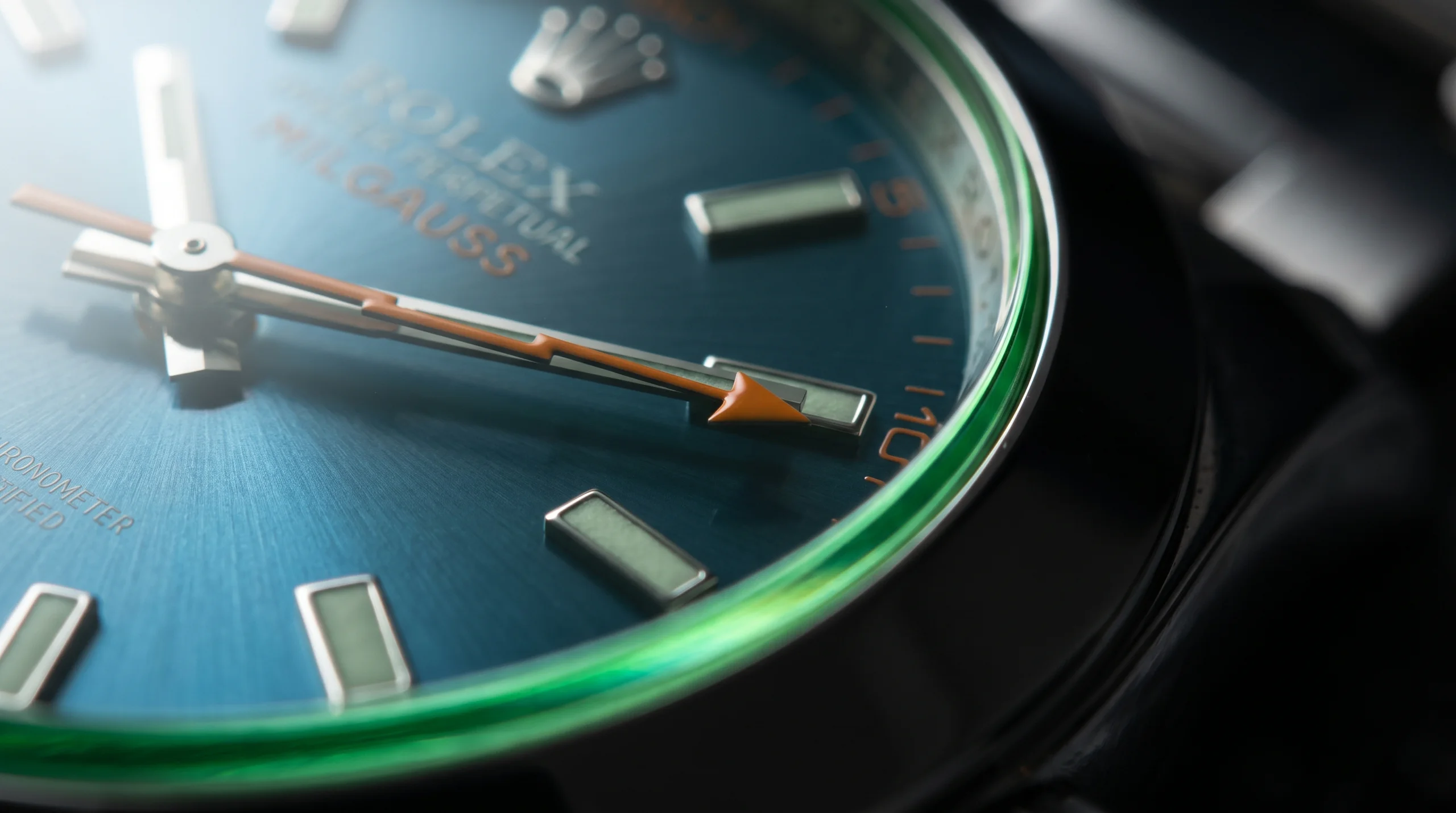 Macro of the Rolex Milgauss orange lightning-bolt seconds hand and green crystal