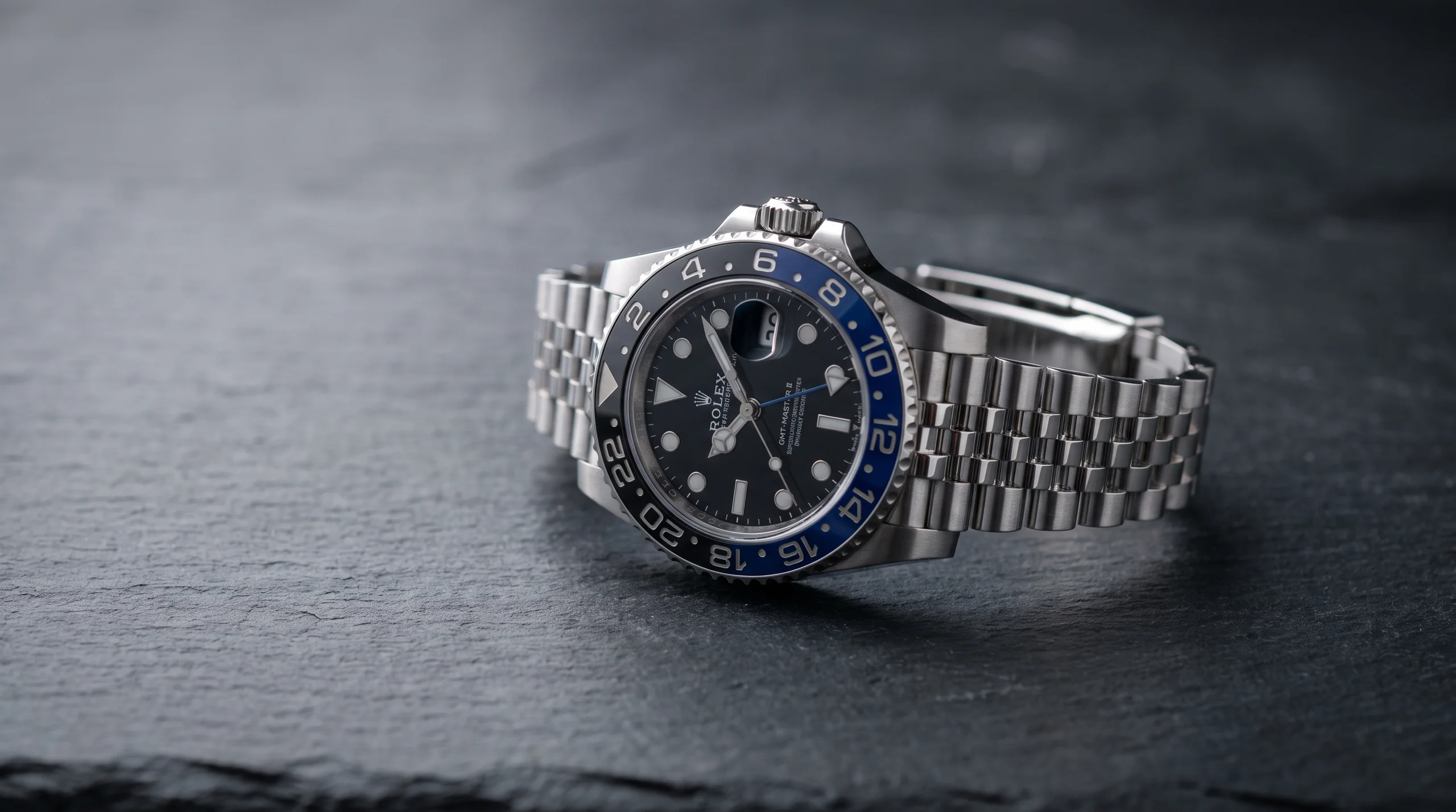 Rolex GMT-Master II Batgirl with a black-and-blue bezel on a five-link Jubilee bracelet on dark slate