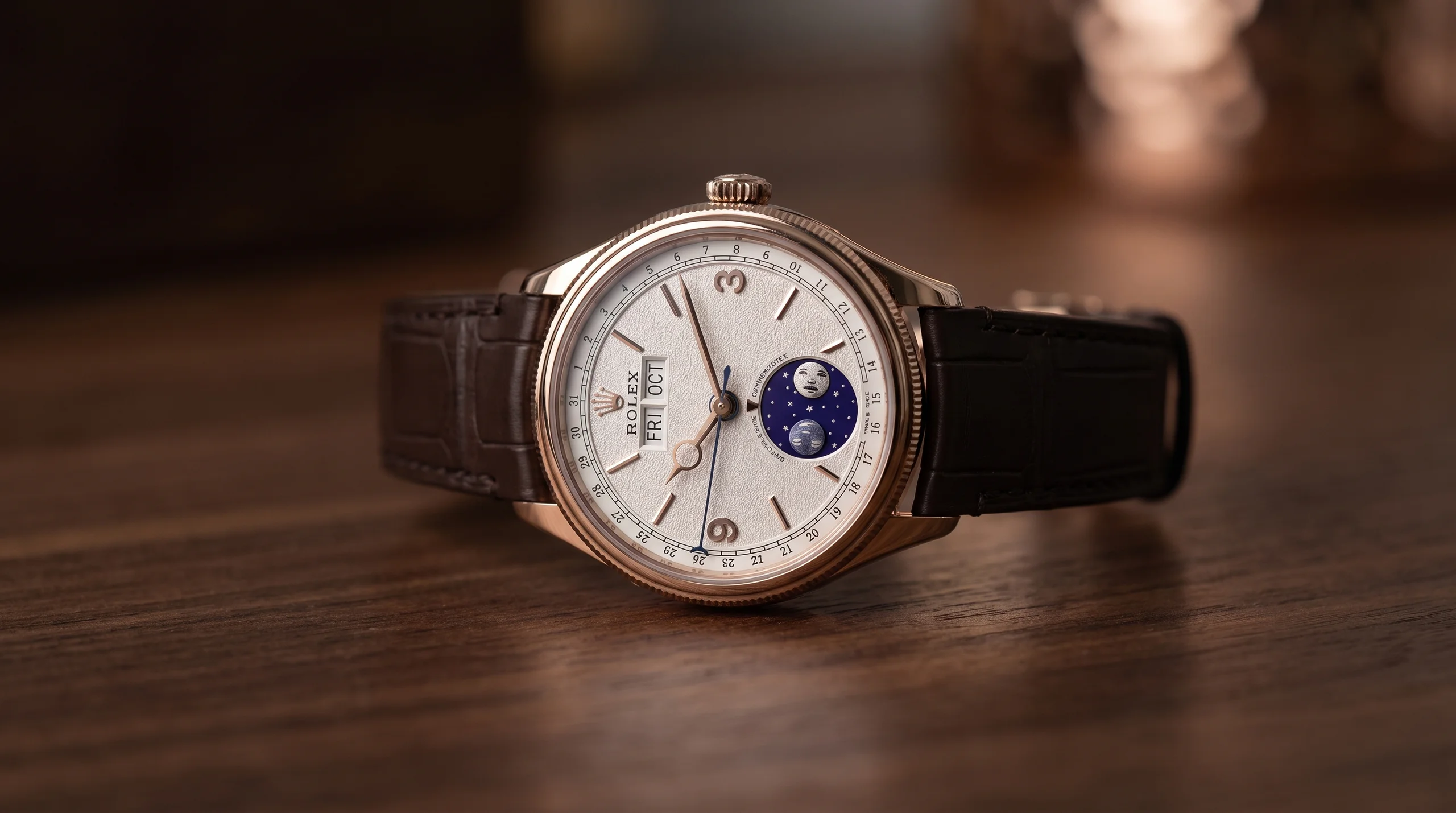 Rolex Perpetual Padellone in Everose gold with moonphase dial on a dark wood surface
