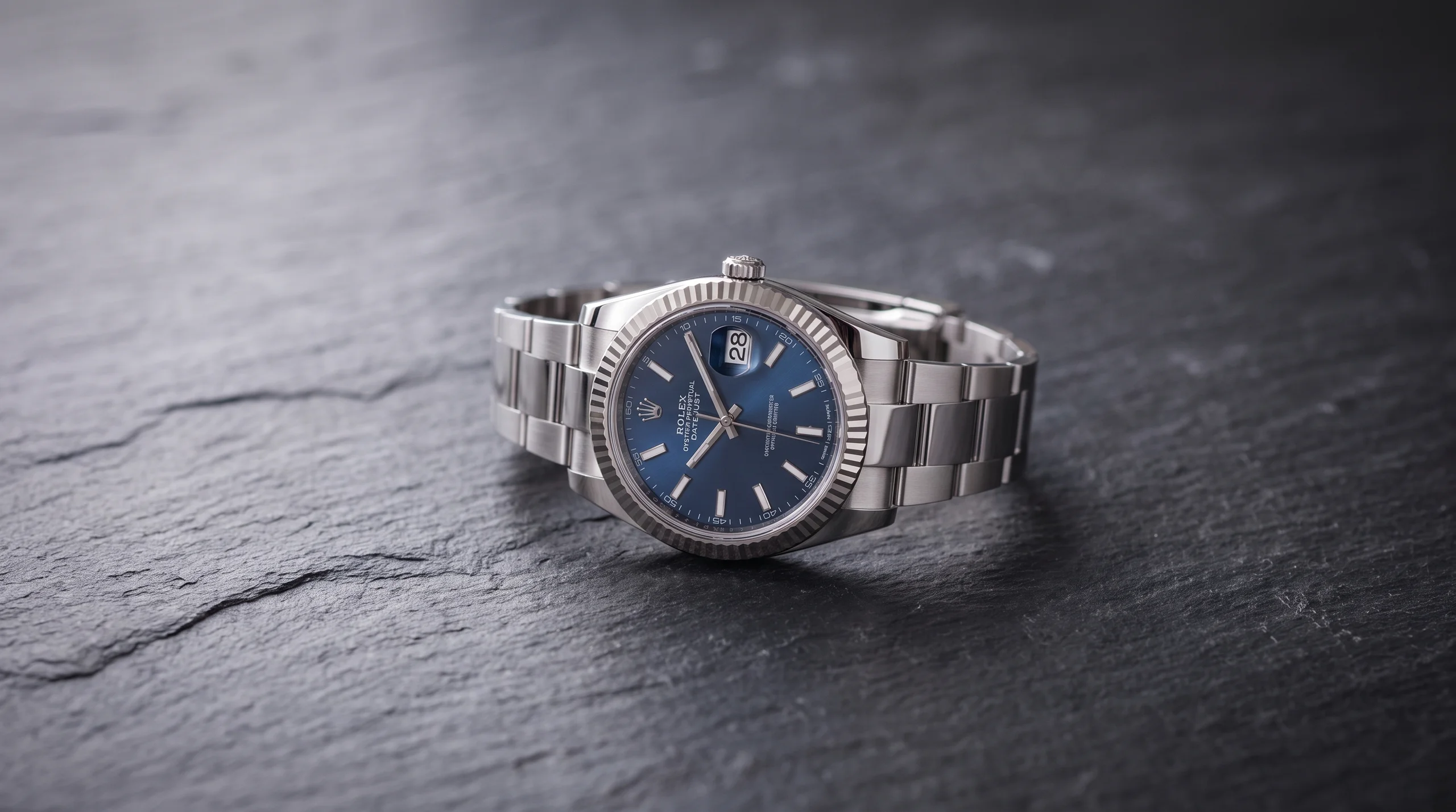 Rolex Datejust 41 with a blue dial and fluted bezel on a steel Jubilee bracelet on dark slate