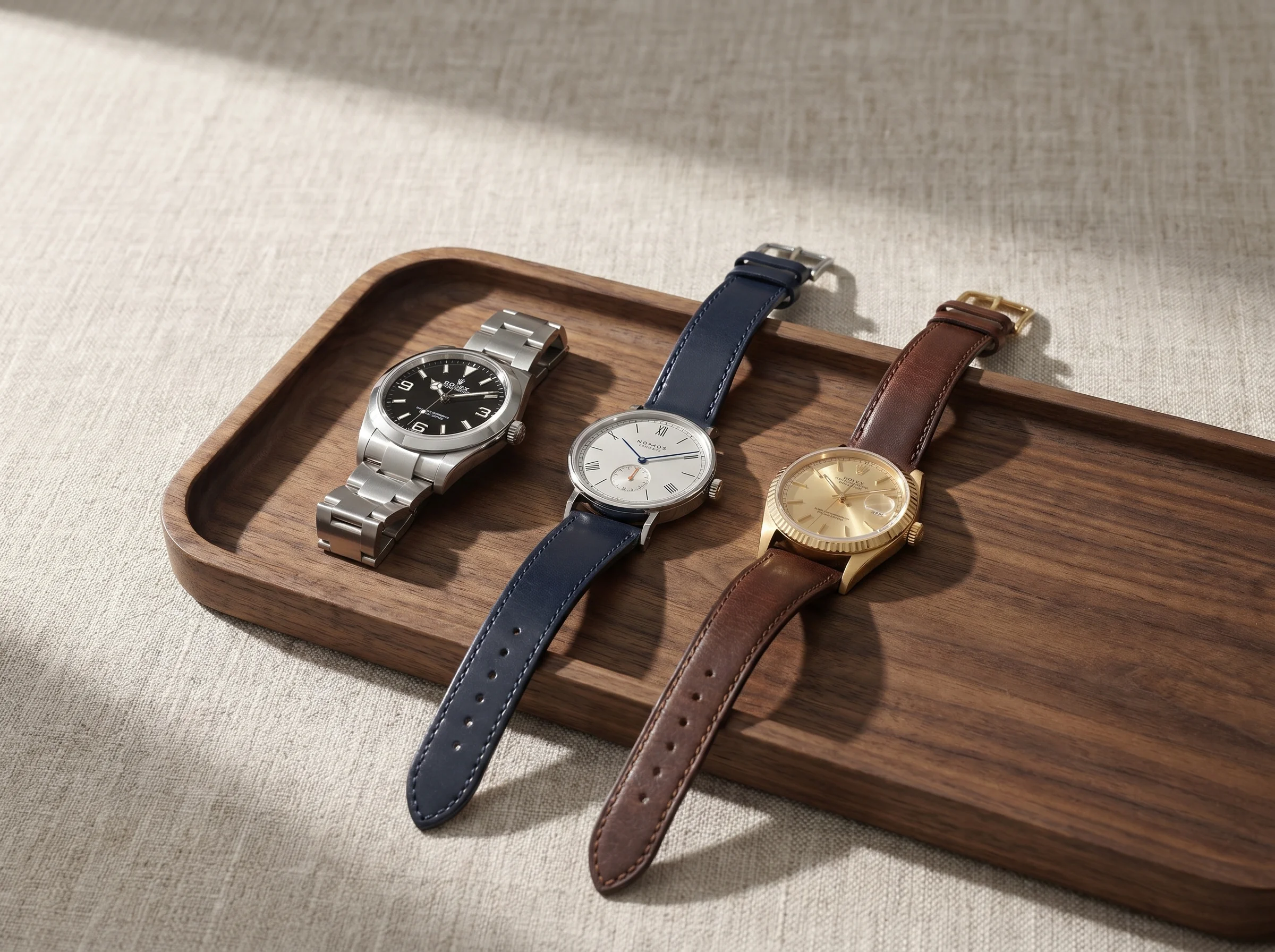 Three classically sized watches on a walnut tray in the 36 to 39mm range