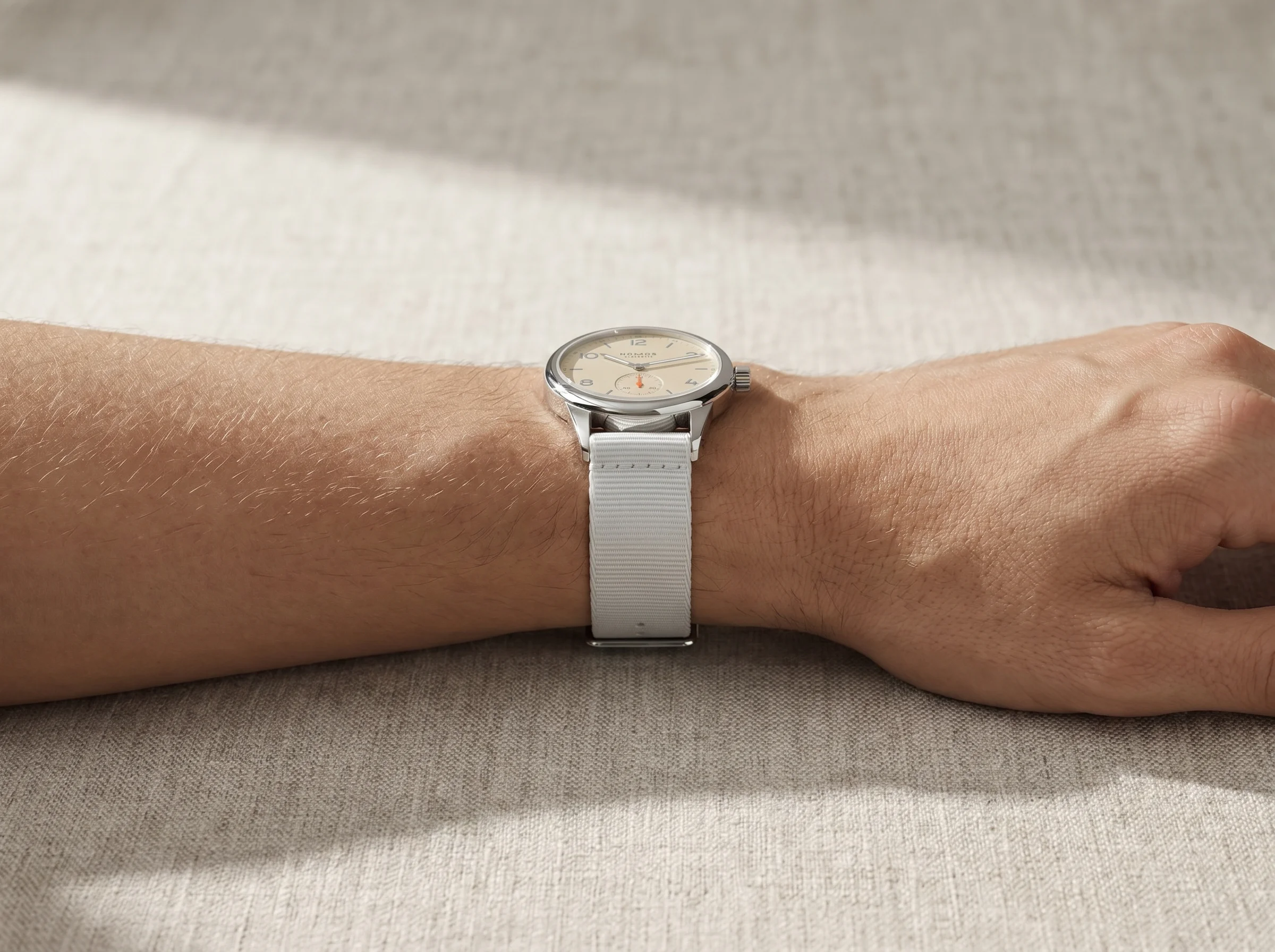 Compact watch on a wrist from the side showing short lug-to-lug with no overhang