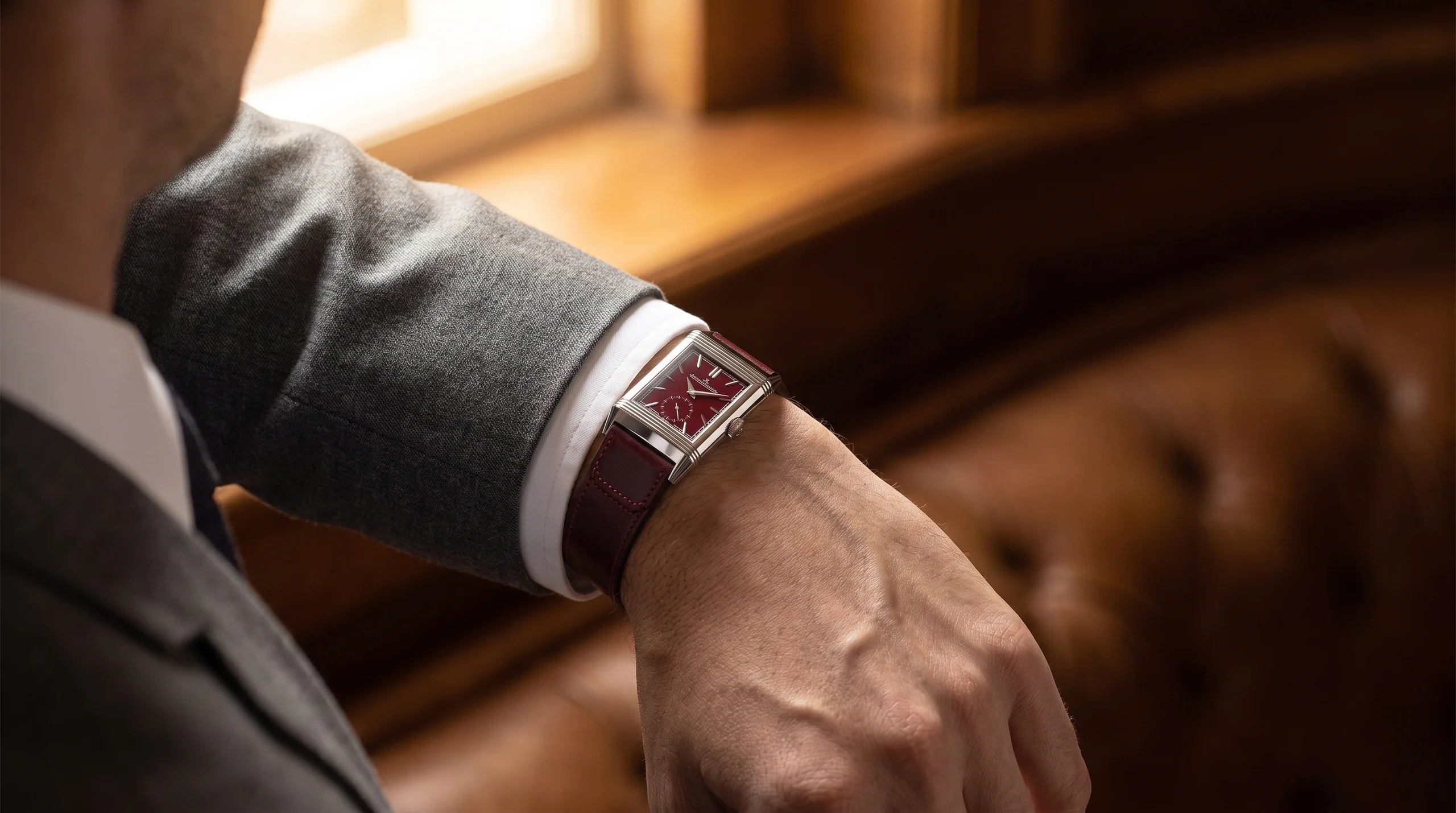 Jaeger-LeCoultre Reverso Tribute worn under a suit cuff, showing its rectangular Art Deco proportions