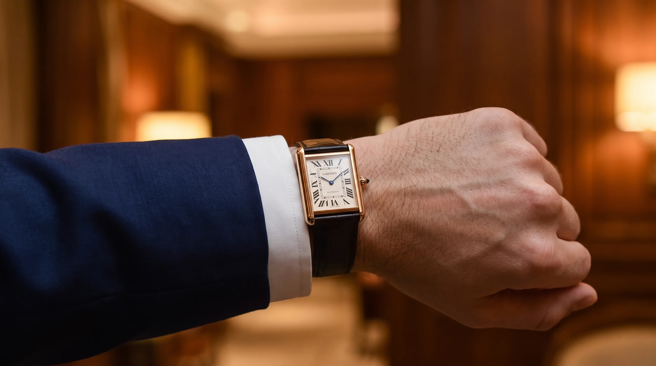 Gold Cartier Tank Louis Cartier worn under a suit cuff, the pure dress-watch rival to the Reverso