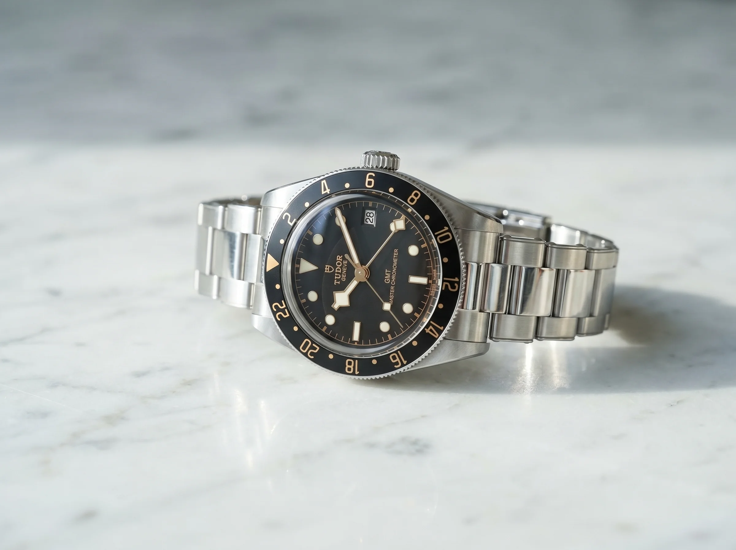 Bright polished steel dive watch on a marble surface