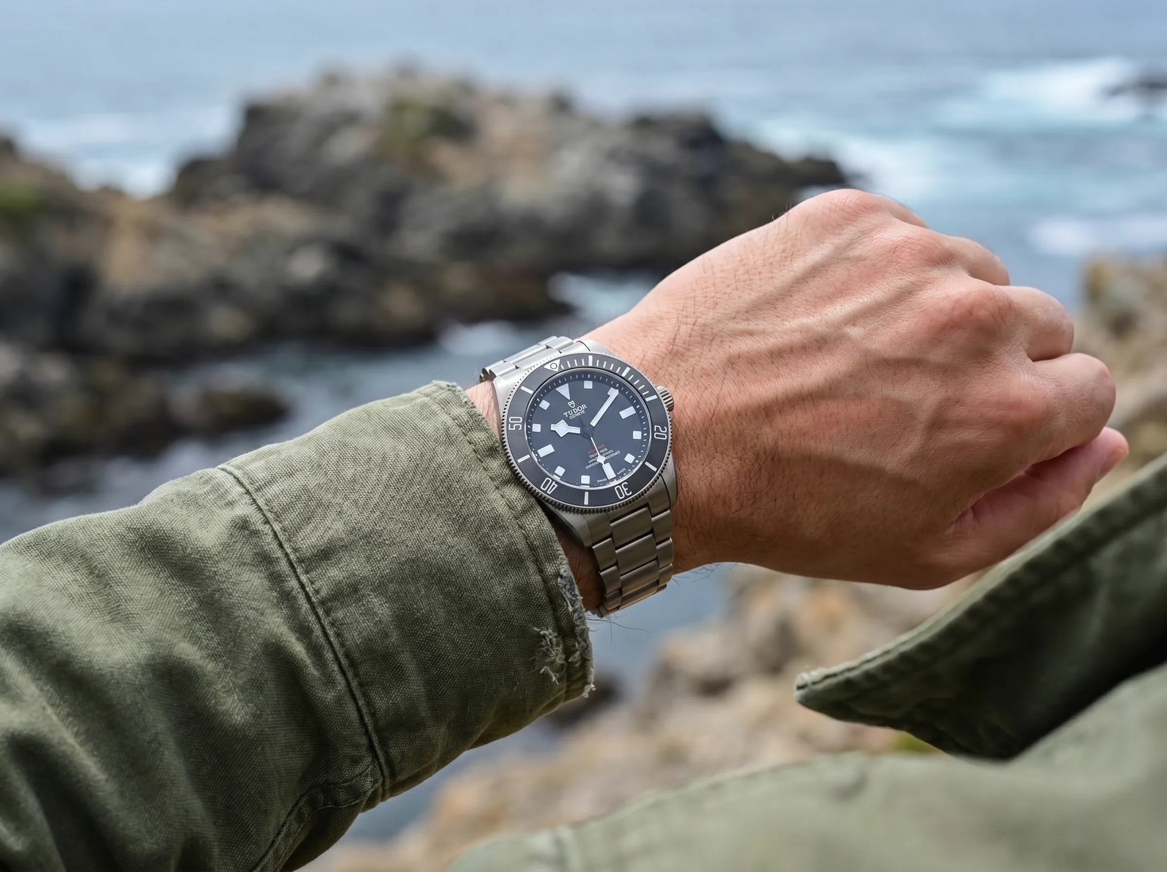 Matte titanium dive watch worn on a wrist over a canvas sleeve