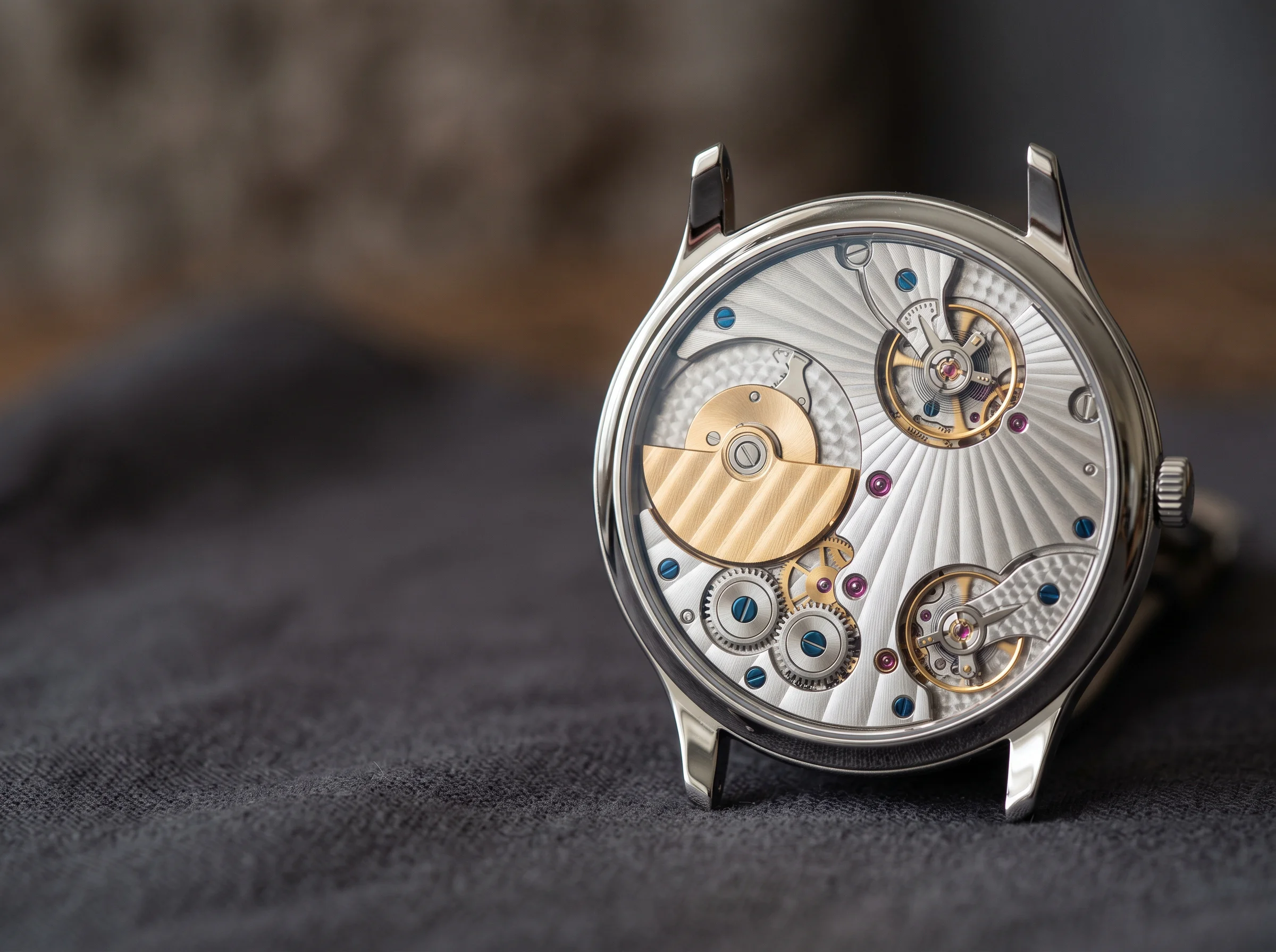 The sapphire caseback of an ultra-thin watch revealing a finely finished micro-rotor movement with radiating stripes