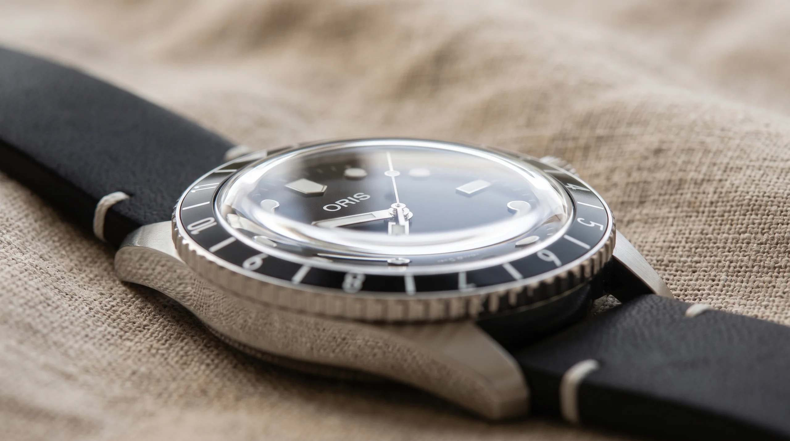 Macro of a high domed crystal bending the dial at the edge, the look domed acrylic and sapphire crystals give