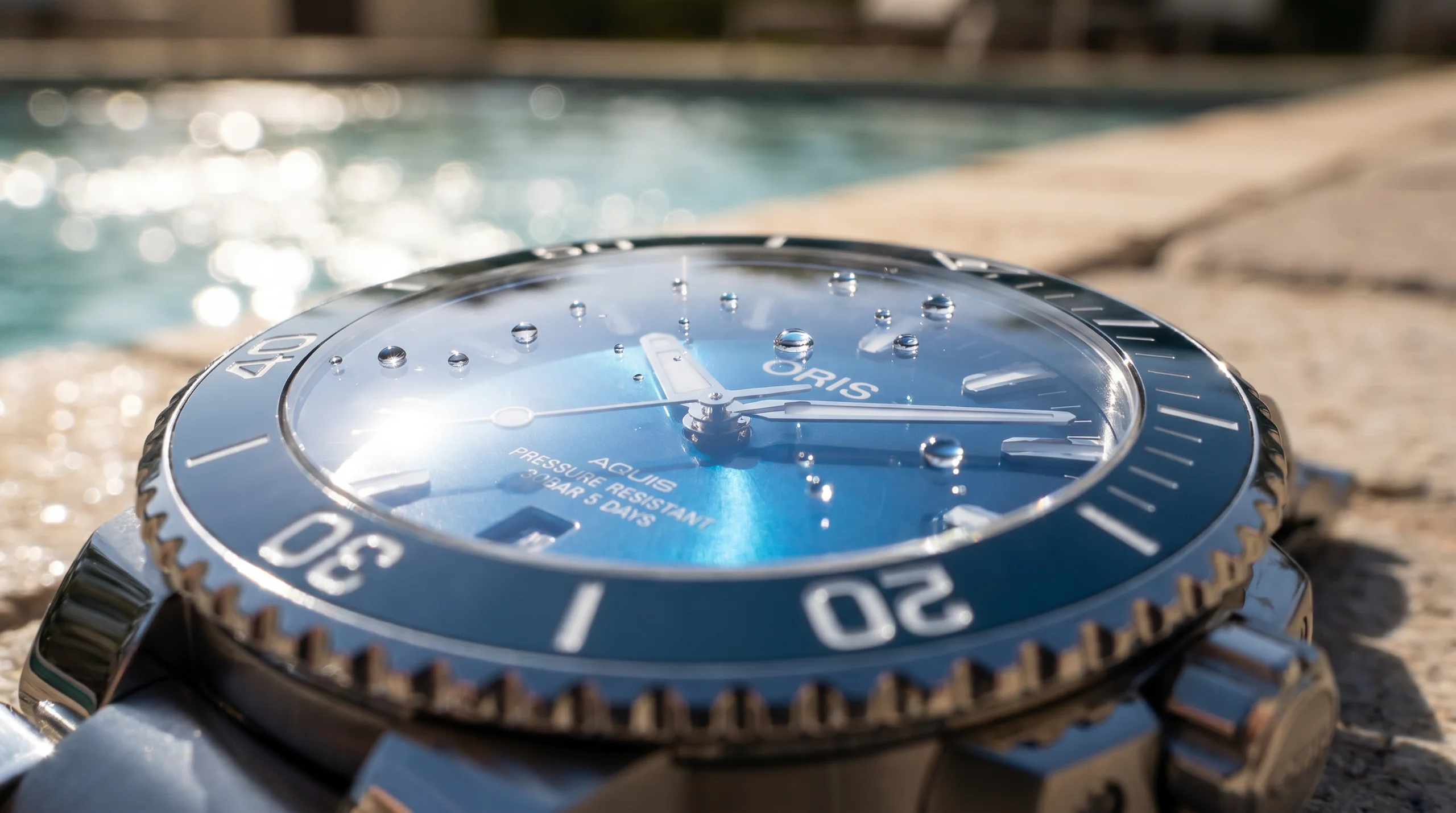 Flat sapphire crystal with blue anti-reflective coating and water droplets on a dive watch