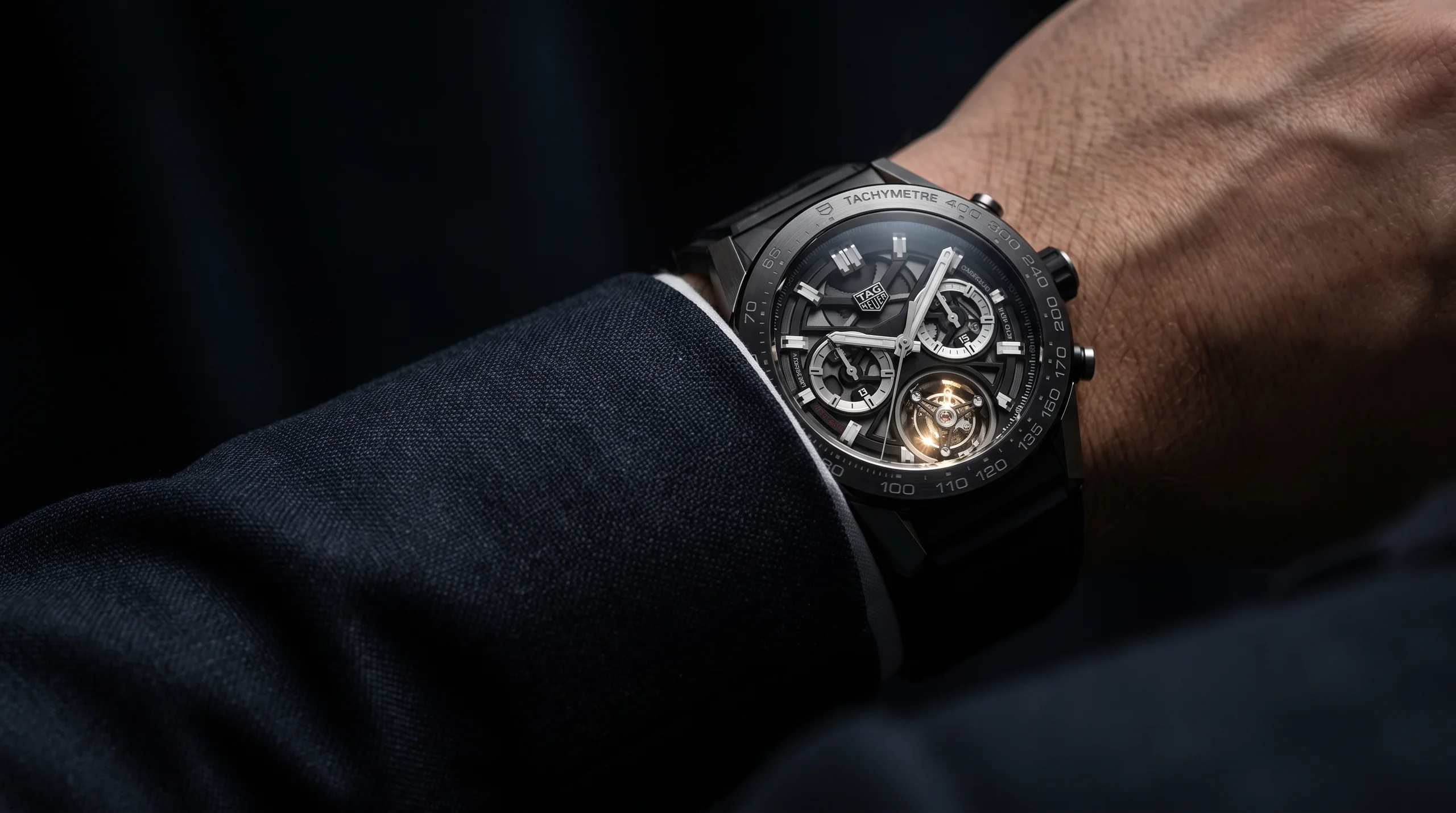 A tourbillon watch worn on the wrist, the spinning cage catching the light at 6 o'clock