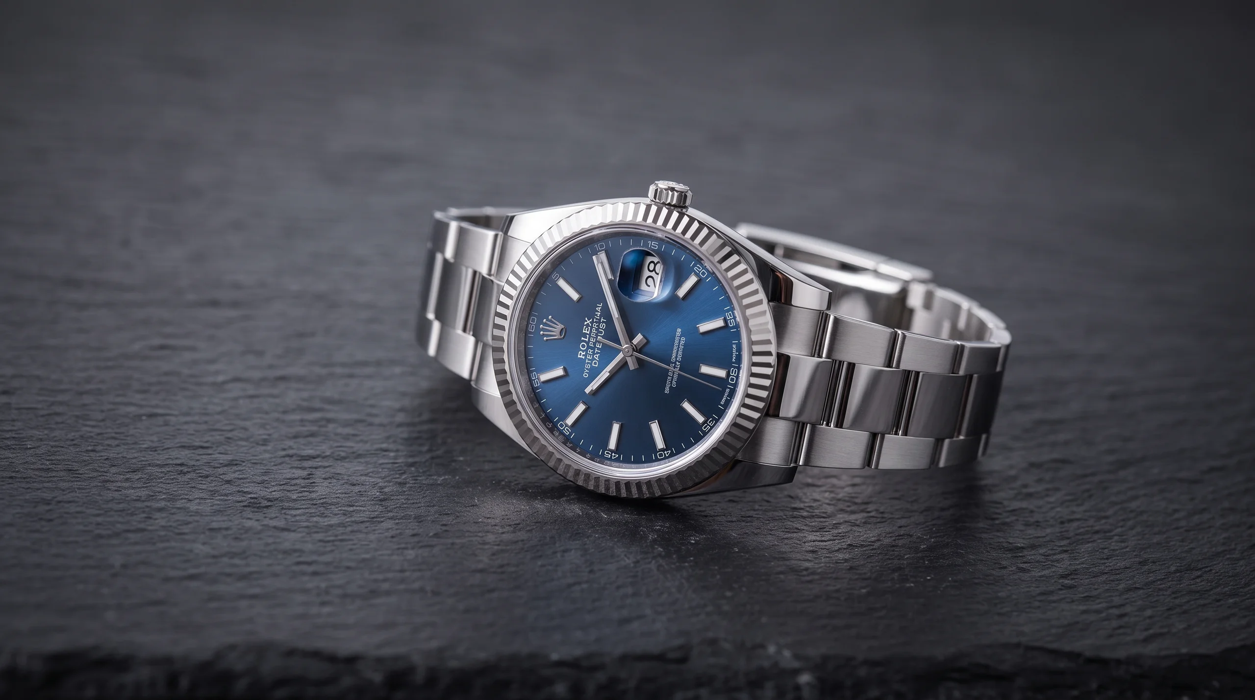 A classic Rolex Datejust with a blue dial and Jubilee bracelet on dark slate, a well-proportioned watch size